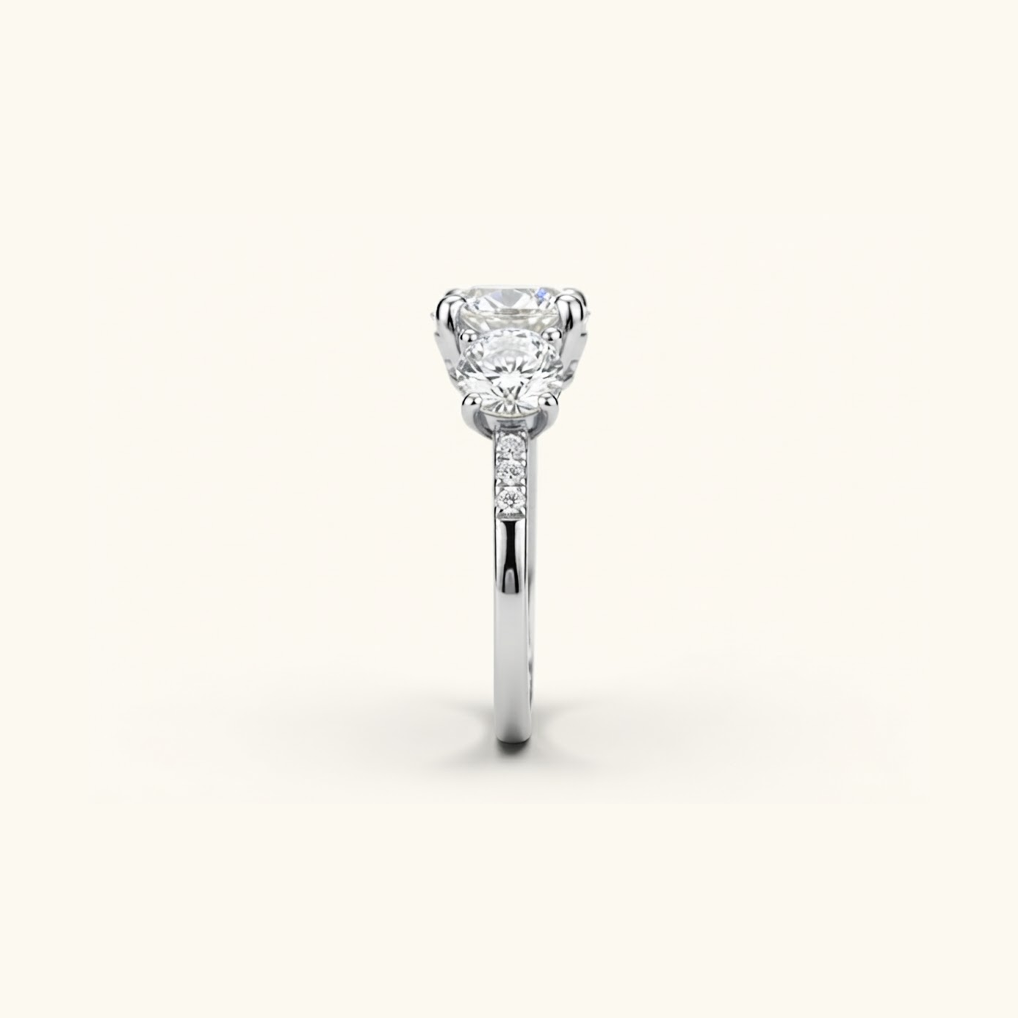 Side profile of the Celia Ring in white gold, showing the raised prong setting and pavé accents along the band.

variant: white-gold