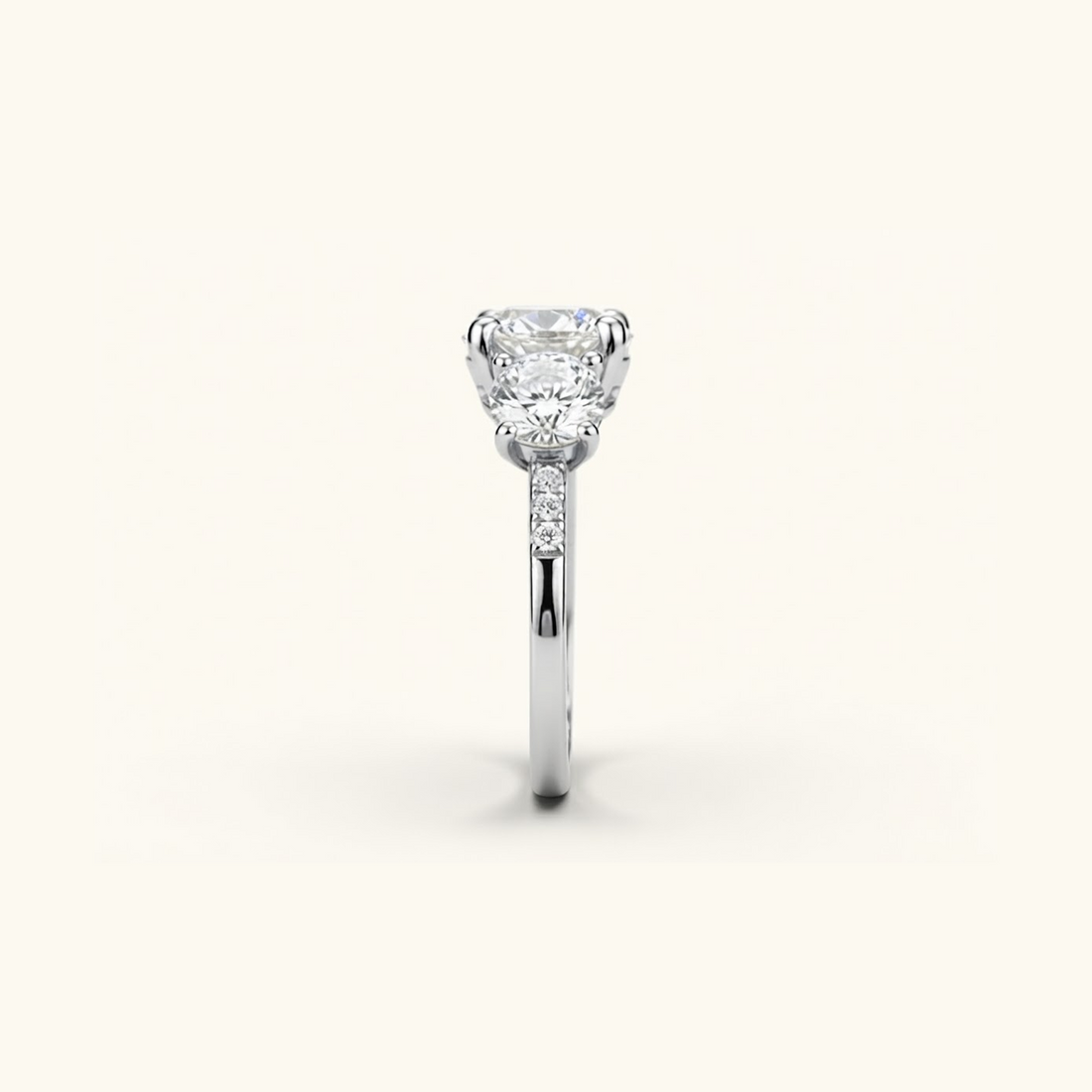 Side profile of the Celia Ring in white gold, showing the raised prong setting and pavé accents along the band.

variant: white-gold