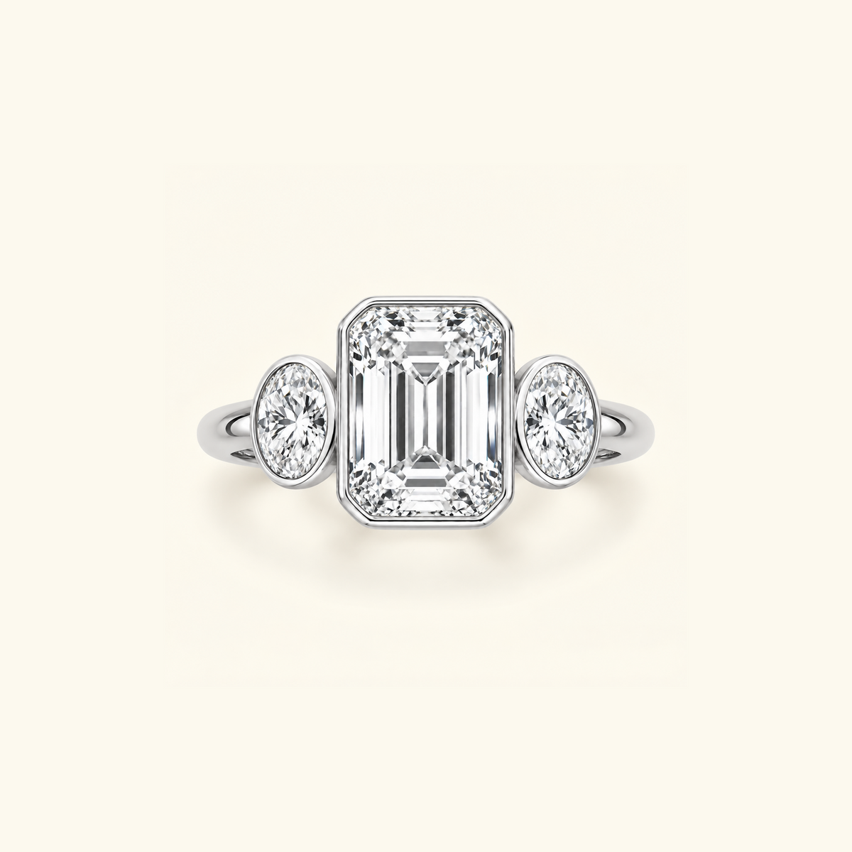 Clio Three-Stone ring in 14K white gold with a bezel-set emerald-cut lab diamond between two oval side stones
variant: white-gold
