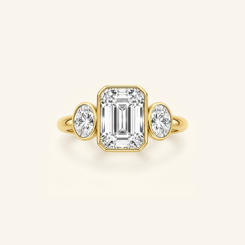 Clio Three-Stone ring in 14K yellow gold with a bezel-set emerald-cut lab diamond between two oval side stones
variant: yellow-gold