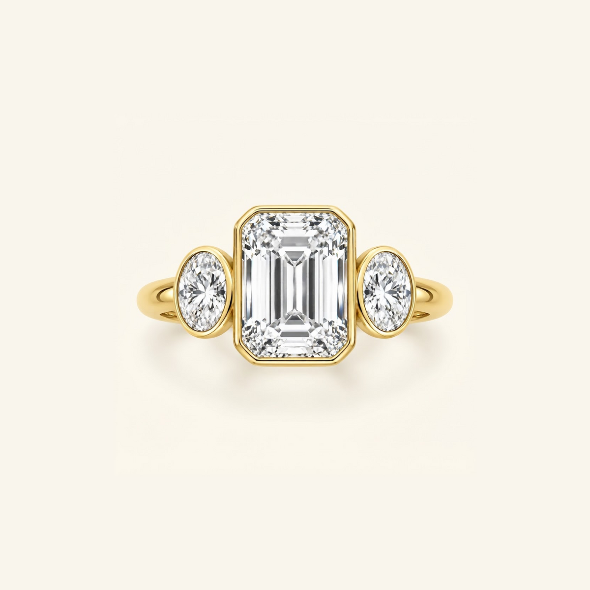 Clio Three-Stone ring in 14K yellow gold with a bezel-set emerald-cut lab diamond between two oval side stones
variant: yellow-gold