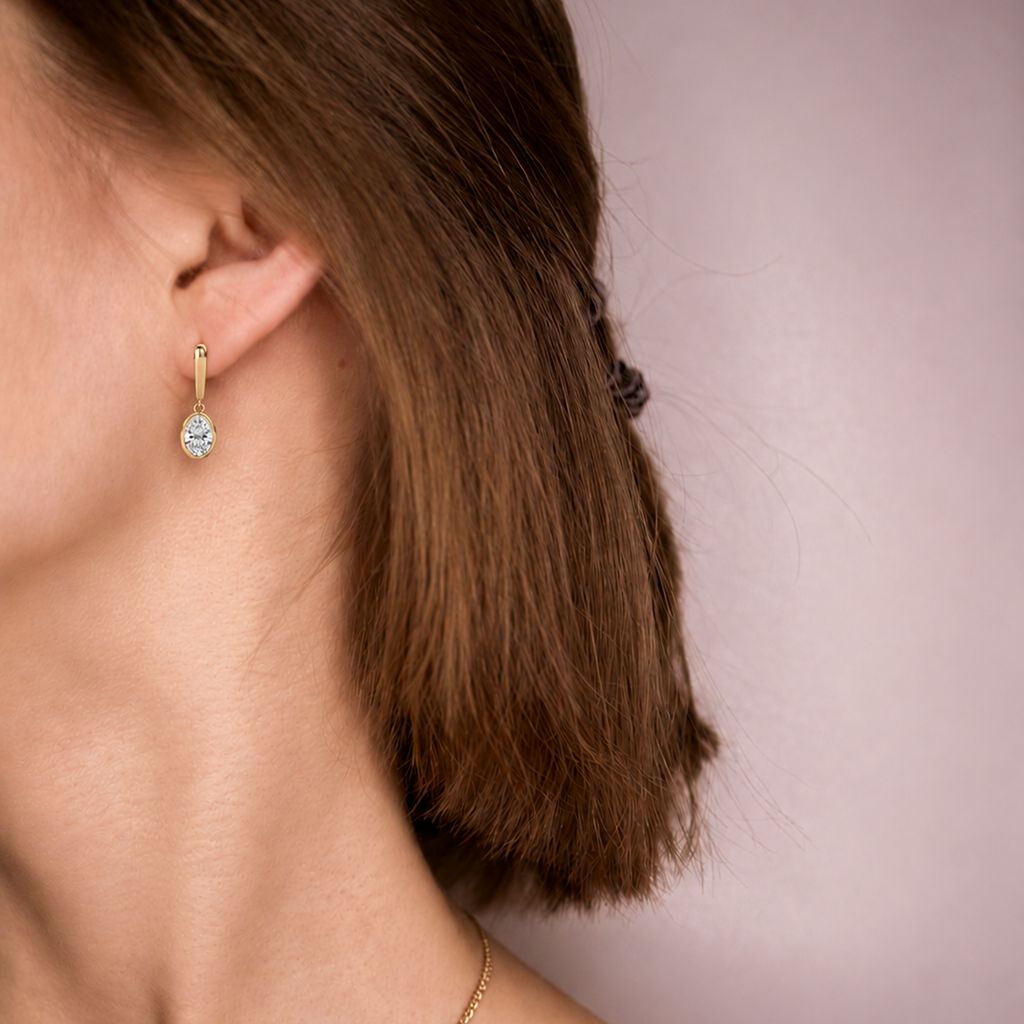 Droplet Earring worn on the ear, an oval diamond drop in yellow gold resting just below the earlobe
variant: yellow-gold