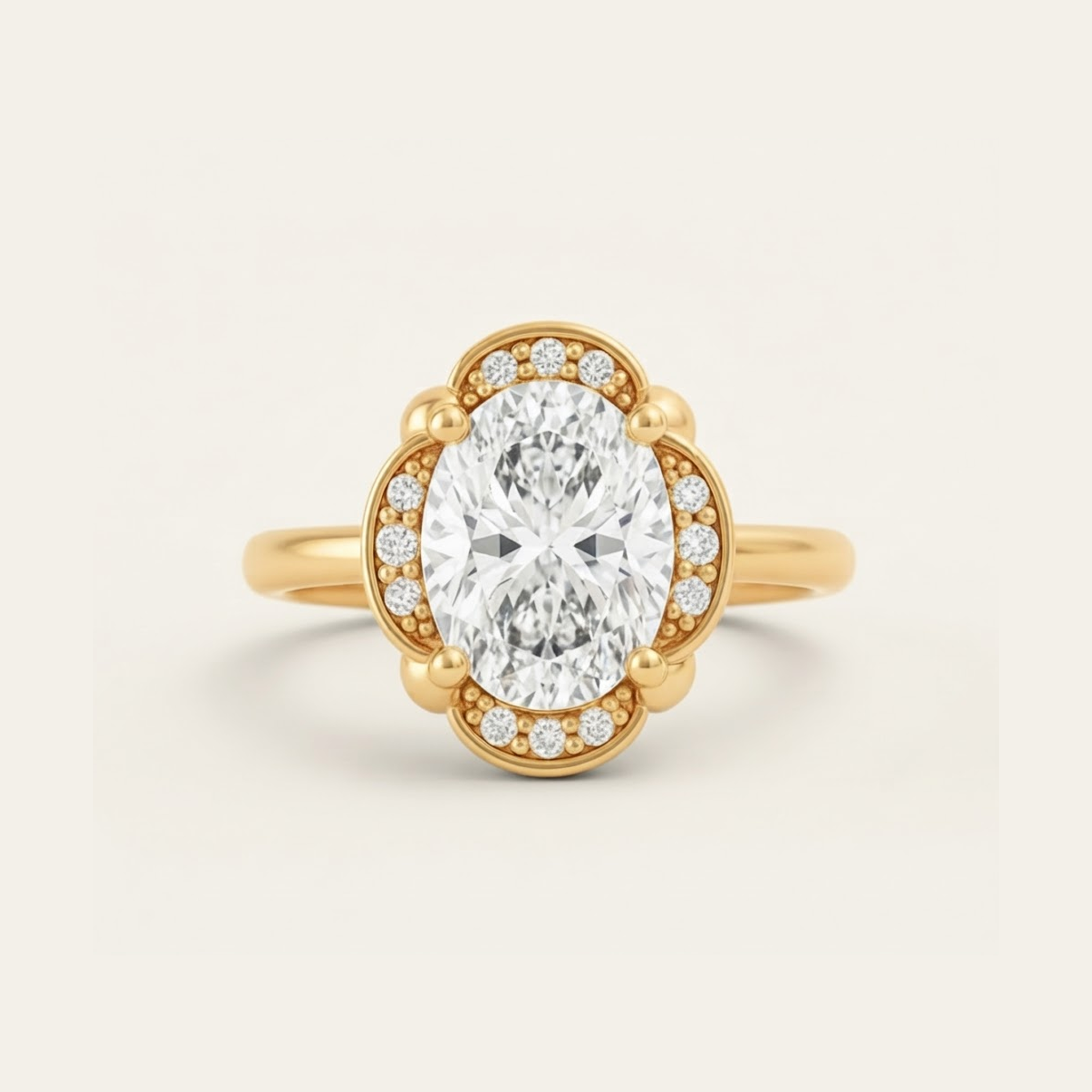 Elise Ring in yellow gold with an oval center diamond in a scalloped halo with beaded milgrain detail, on a cream background.

variant: yellow-gold