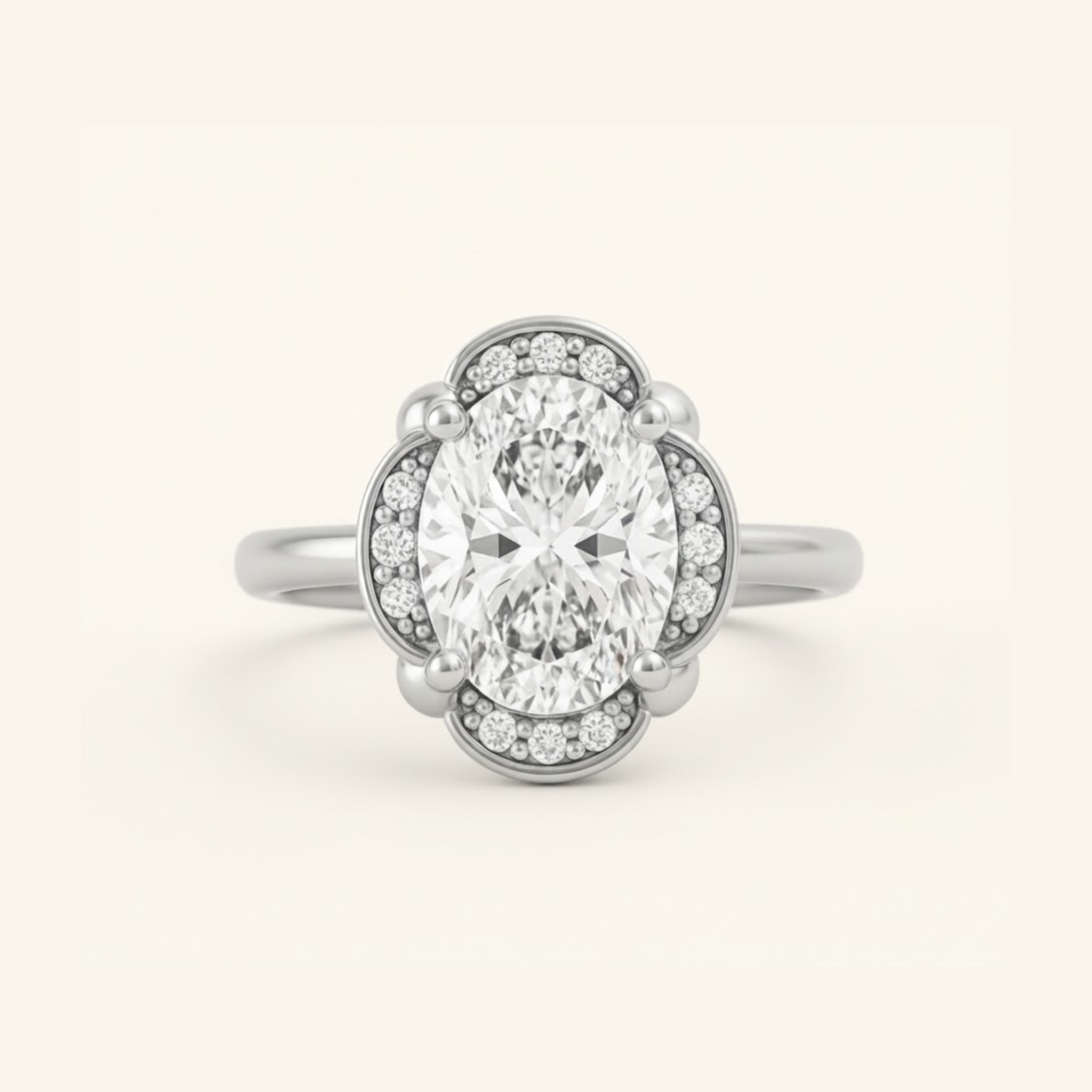 Elise Ring in silver or platinum with an oval center diamond in a scalloped halo with beaded milgrain detail, on a cream background.

variant: silver