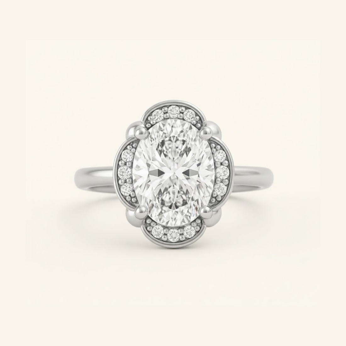 Elise Ring in white gold with an oval center diamond in a scalloped halo with beaded milgrain detail, on a cream background.

variant: white-gold