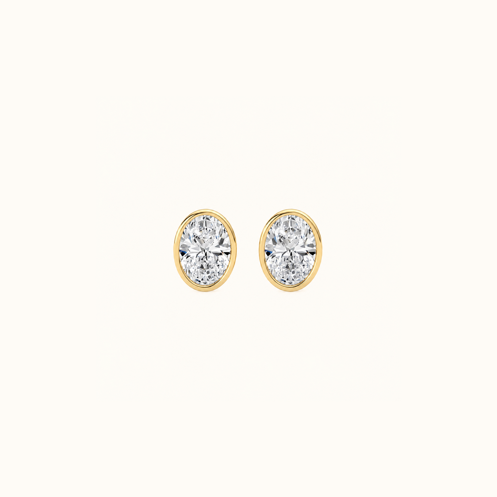 Everly bezel stud in yellow gold with an oval-cut diamond, shown from the front and side to reveal the post and butterfly back