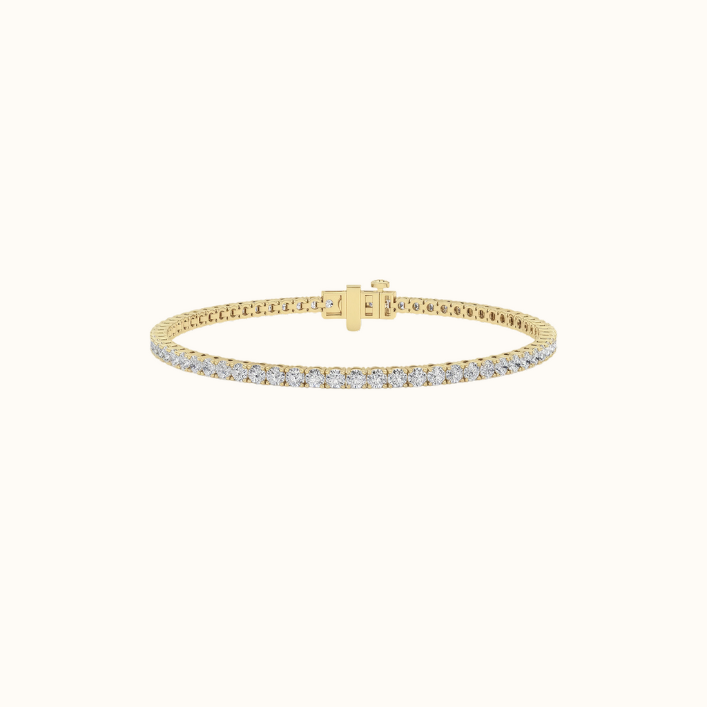 Everly tennis bracelet in yellow gold with a continuous row of round diamonds and a hidden box clasp, on a cream background
variant: yellow-gold