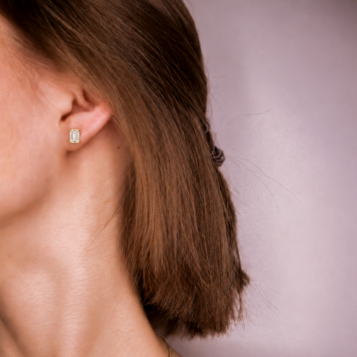 Model wearing an Everly emerald diamond stud, side profile with hair tucked behind the ear
variant: yellow-gold