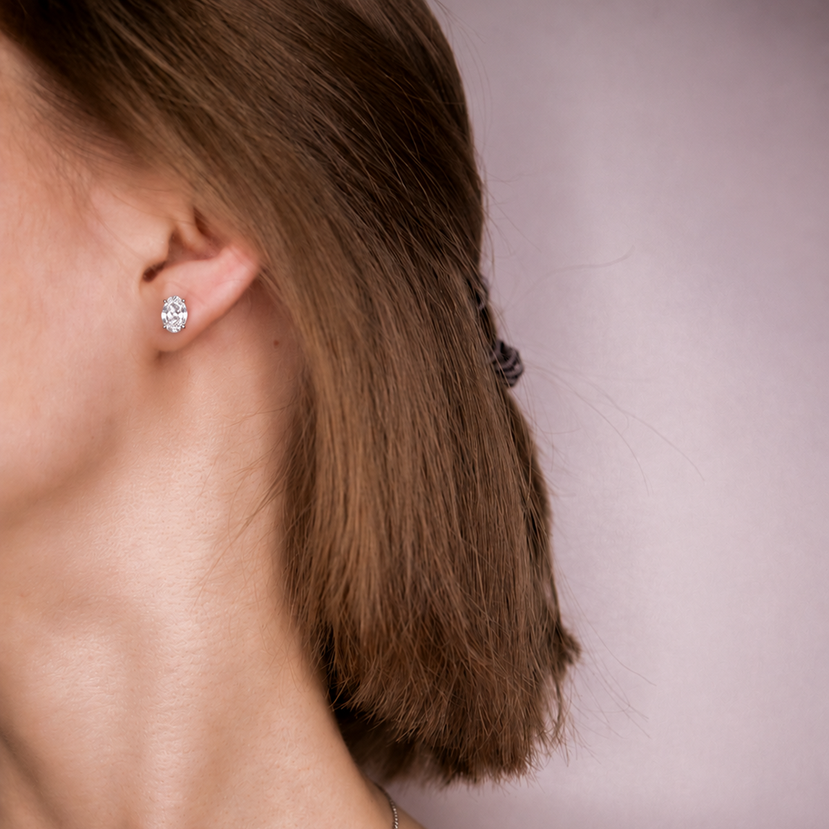 Model wearing an Everly oval diamond stud, side profile with hair tucked behind the ear
variant: silver