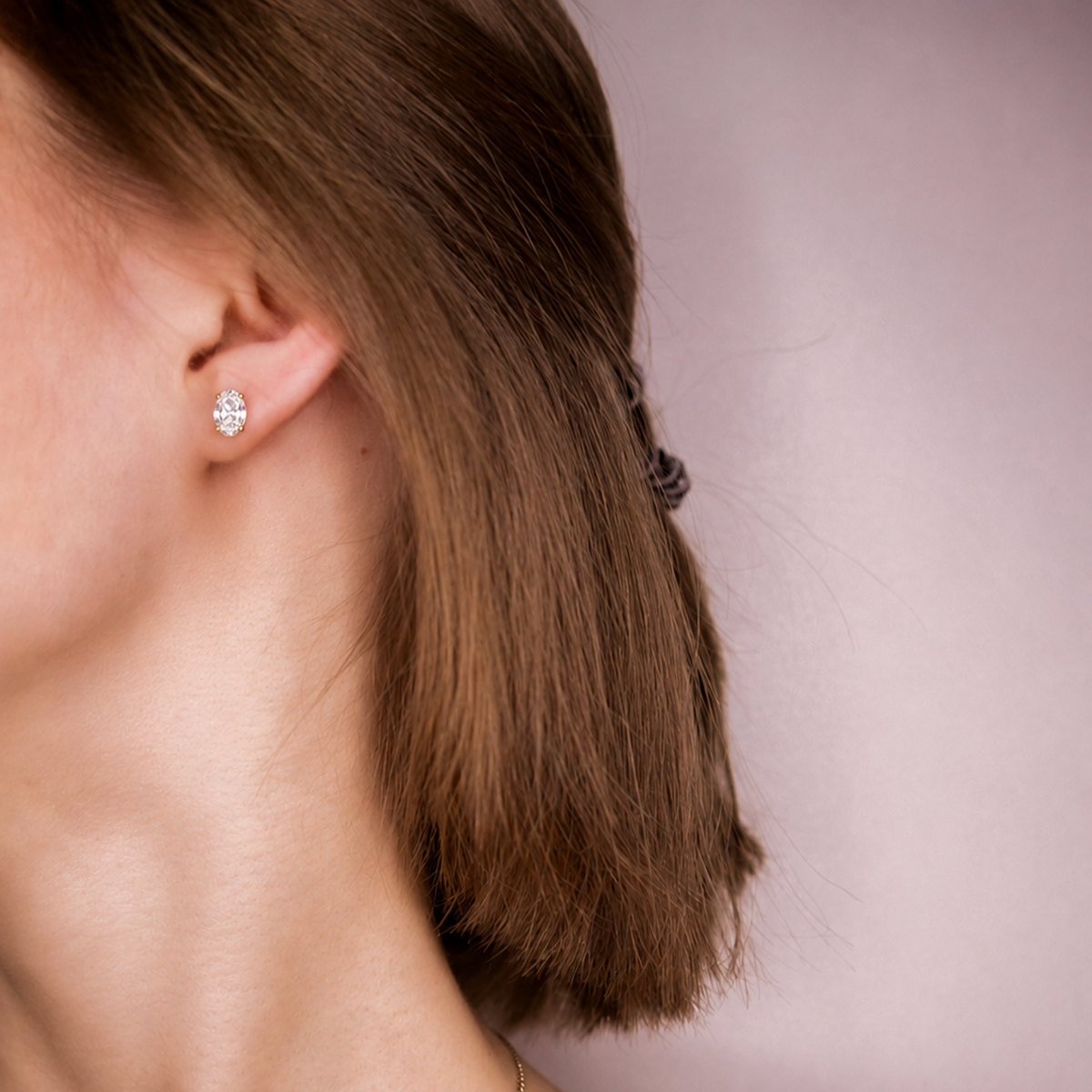Model wearing an Everly oval diamond stud, side profile with hair tucked behind the ear
variant: yellow-gold
