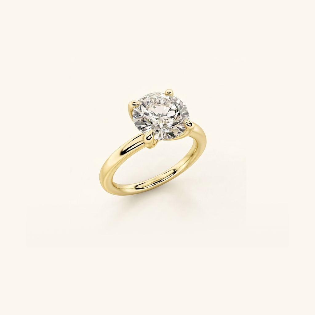 Everly solitaire ring in yellow gold at an angle, showing the 1ct round diamond and the four prongs that hold it
variant: yellow-gold