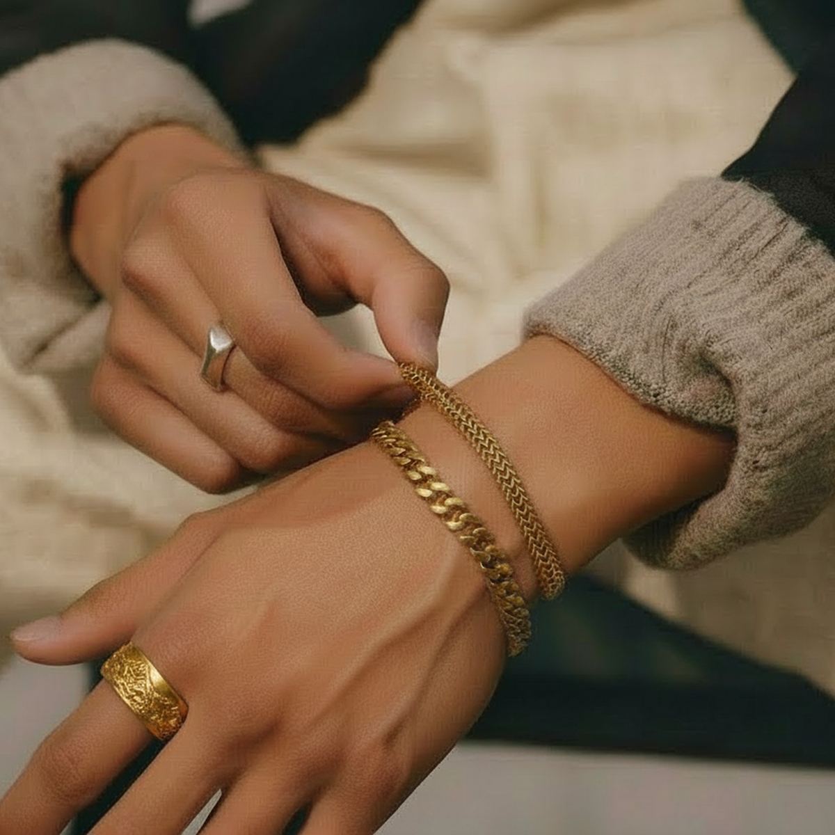 Magnus Ring in yellow gold worn on a hand, styled with a gold chain bracelet and layered rings.
variant: yellow-gold