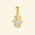 Close-up of the Mira pendant in yellow gold, a hamsa hand fully set with pavé stones and a polished rim.
variant: yellow-gold