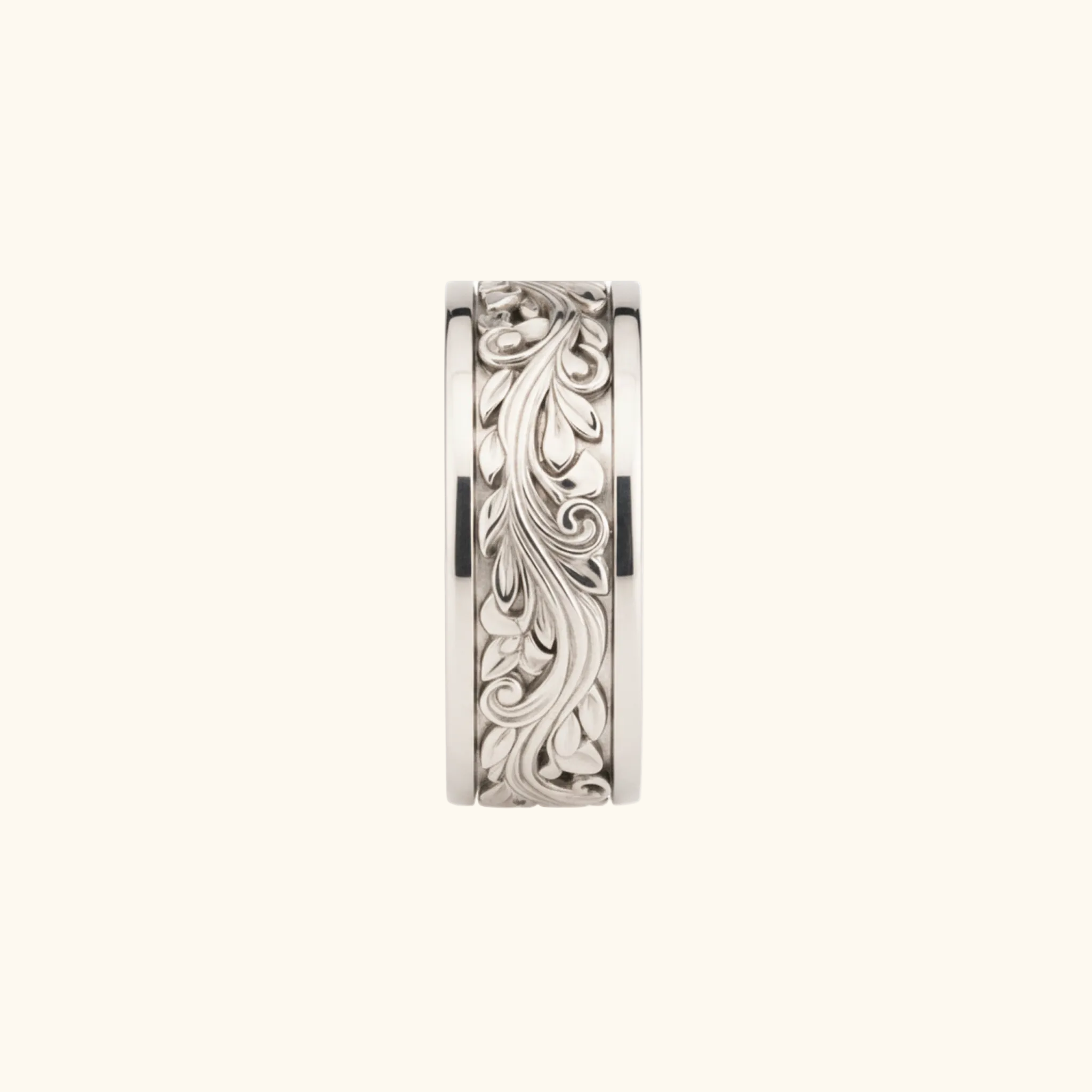 Verona ring in silver featuring an intricate, raised floral scrollwork pattern on its outer face, shown against a light cream background.

variant: silver