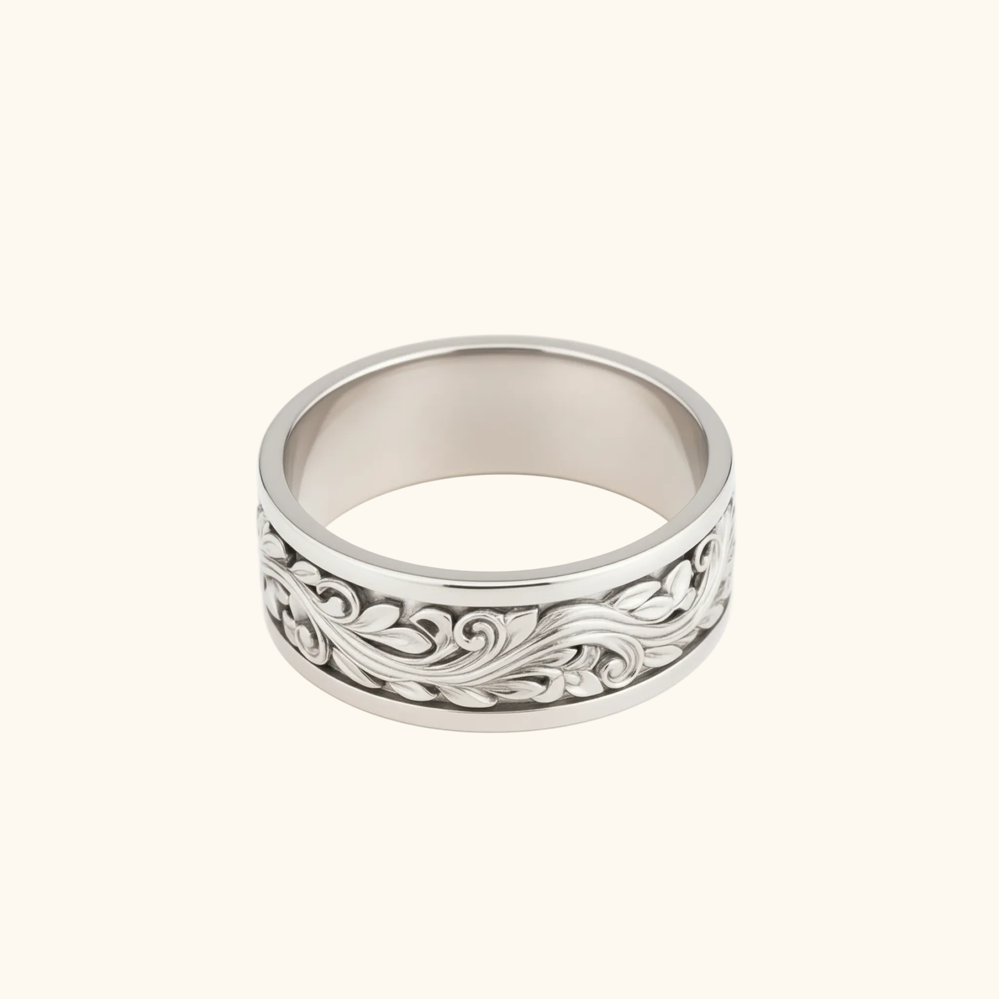 Verona ring in silver featuring an intricate, raised floral scrollwork pattern on its outer face, shown against a light cream background.

variant: white-gold